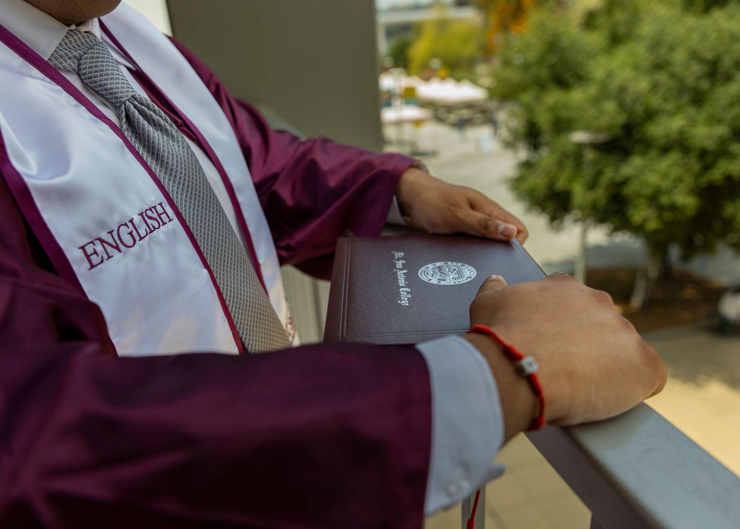 Close-up details of graduation regalia and stoles in maroon and gold colors.