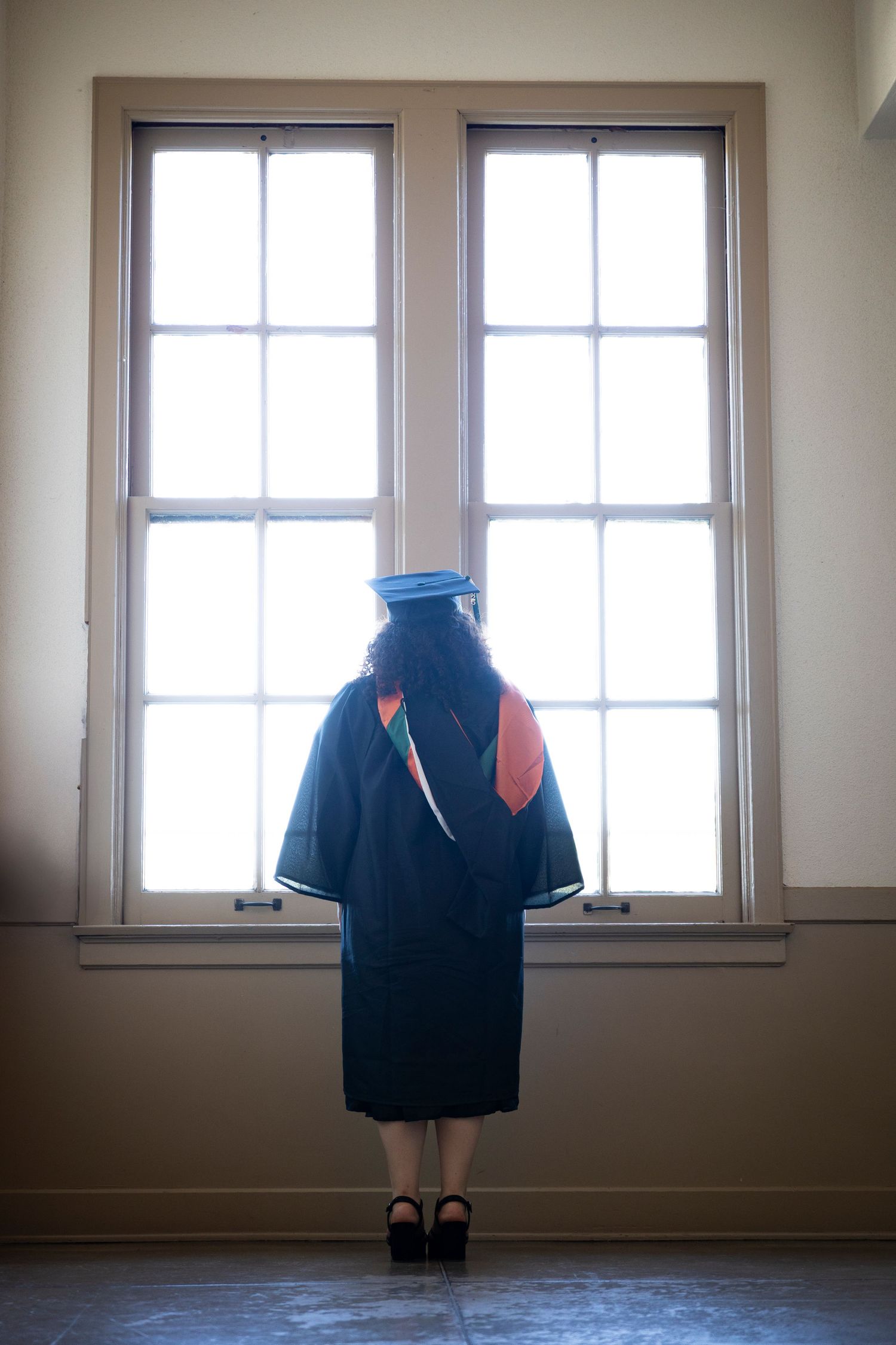 Series of windows with a floating navy blue polo shirt in an empty room.