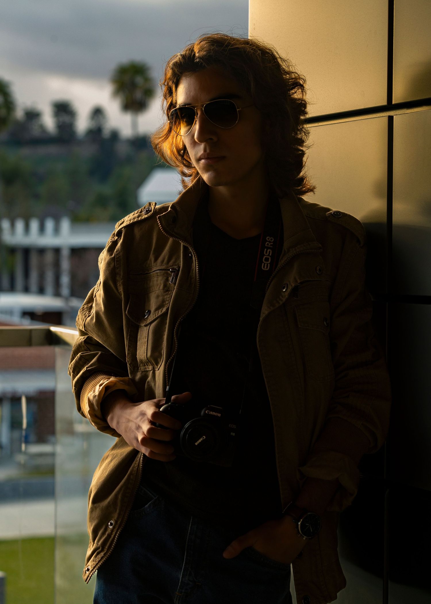 Moody indoor portrait with dramatic side lighting near window.