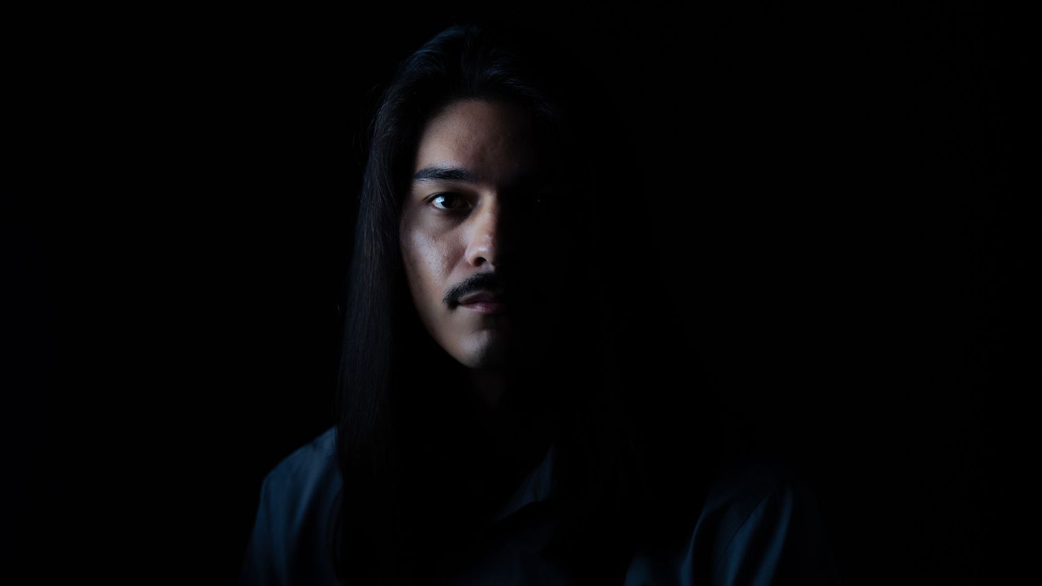 A series of six dark moody portraits in shadow against black backgrounds.