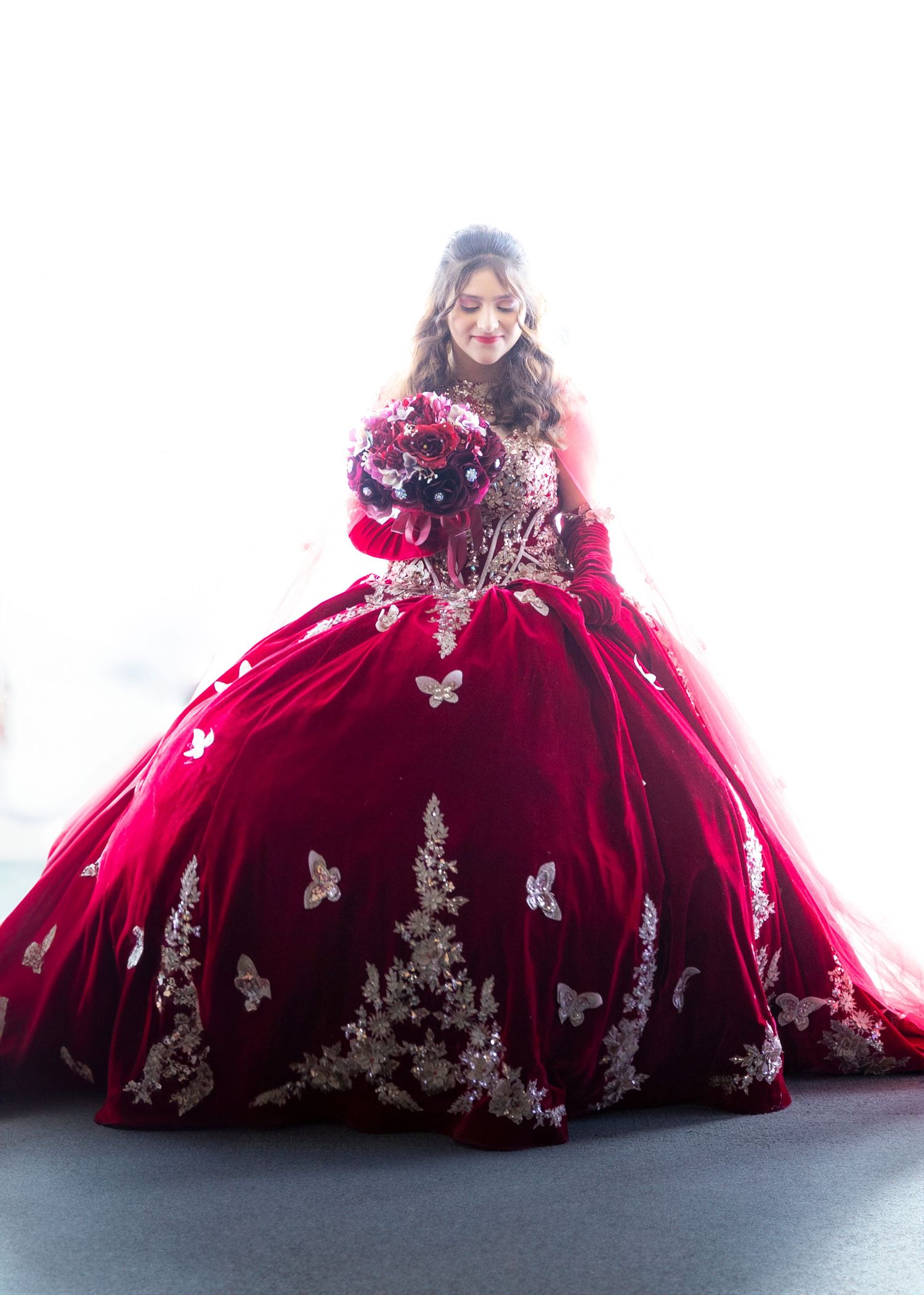 Stunning red velvet quinceanera ball gown with silver embellishments and butterfly details shown from multiple angles.