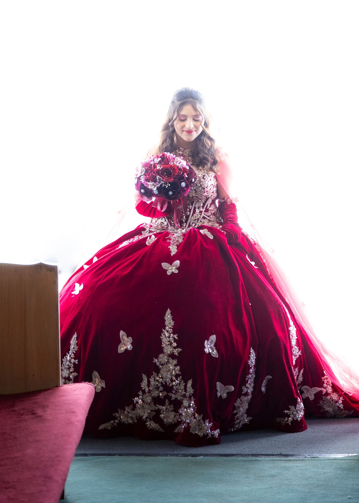 Stunning red velvet ball gown with silver embellishments and dramatic skirt.