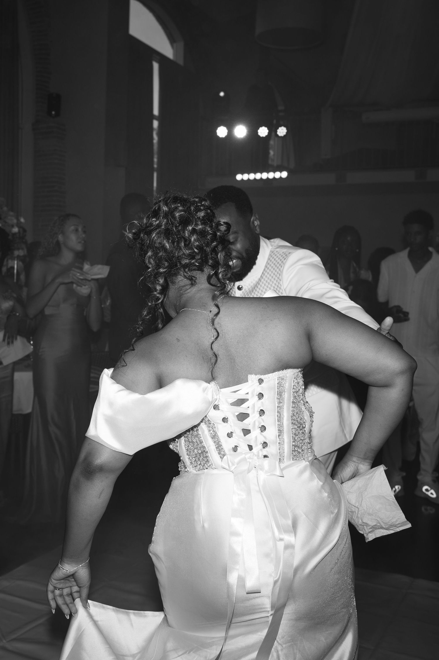 Black and white photo of bride and groom sharing first dance at wedding reception.