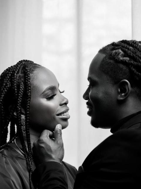 Black and white romantic portrait of couple facing each other, man gently holding womans face.