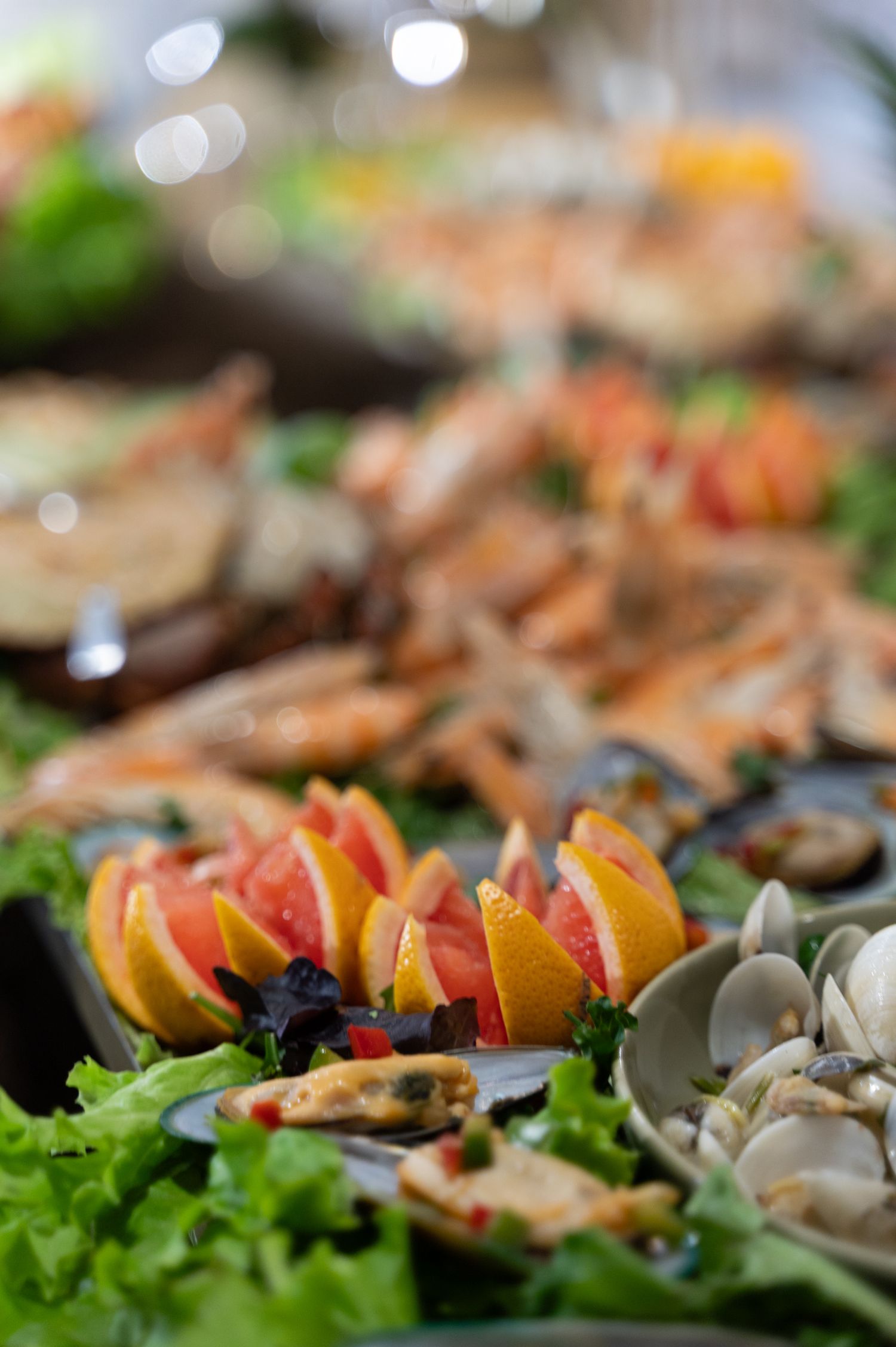Seafood buffet display with shrimp, mussels, and citrus garnish at catered event.
