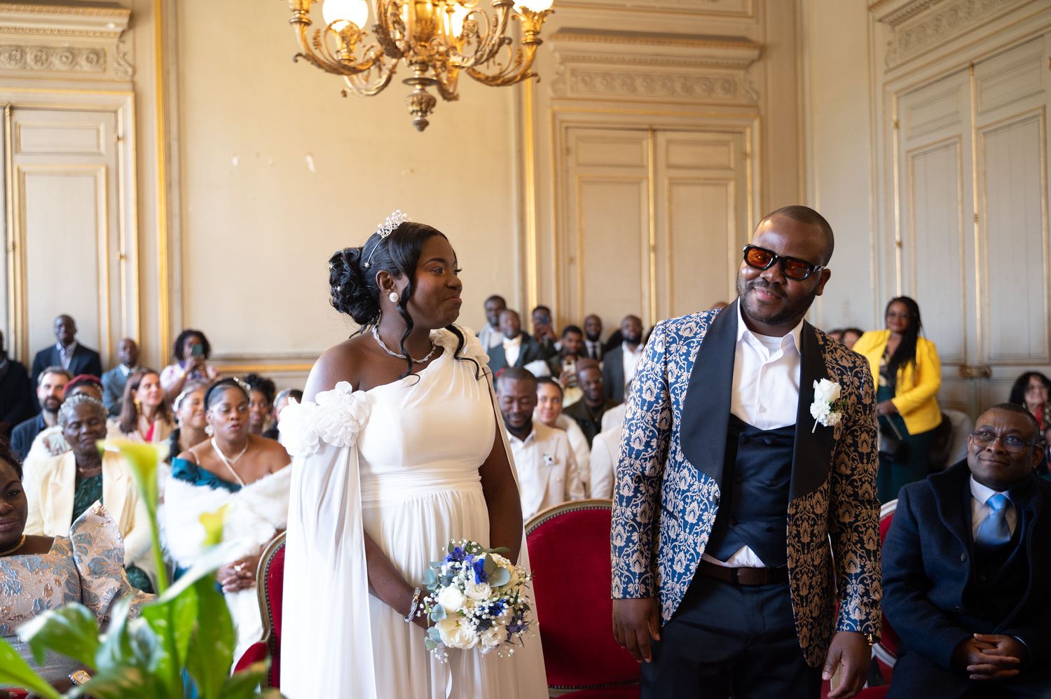 Bride and groom sharing a joyful moment at elegant wedding ceremony in ornate hall.