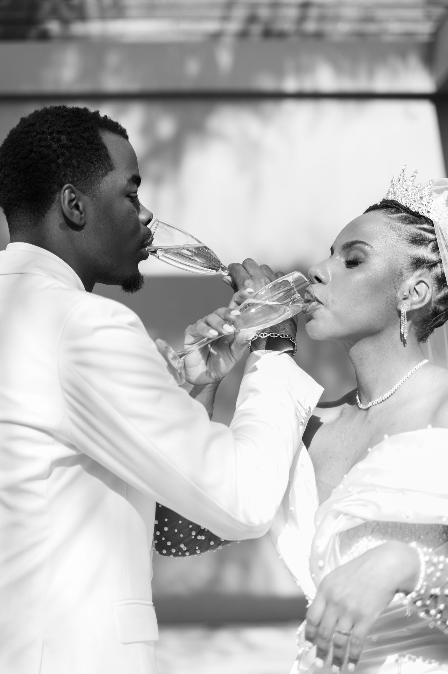 Black and white photo of bride and groom sharing champagne toast at wedding.