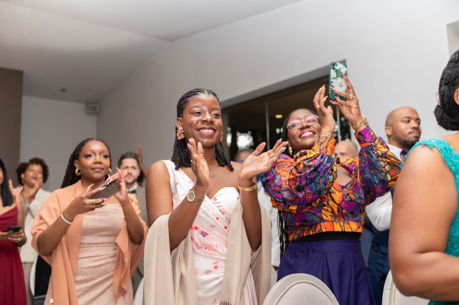 Joyful wedding guests clapping and celebrating at a lively indoor wedding reception party.