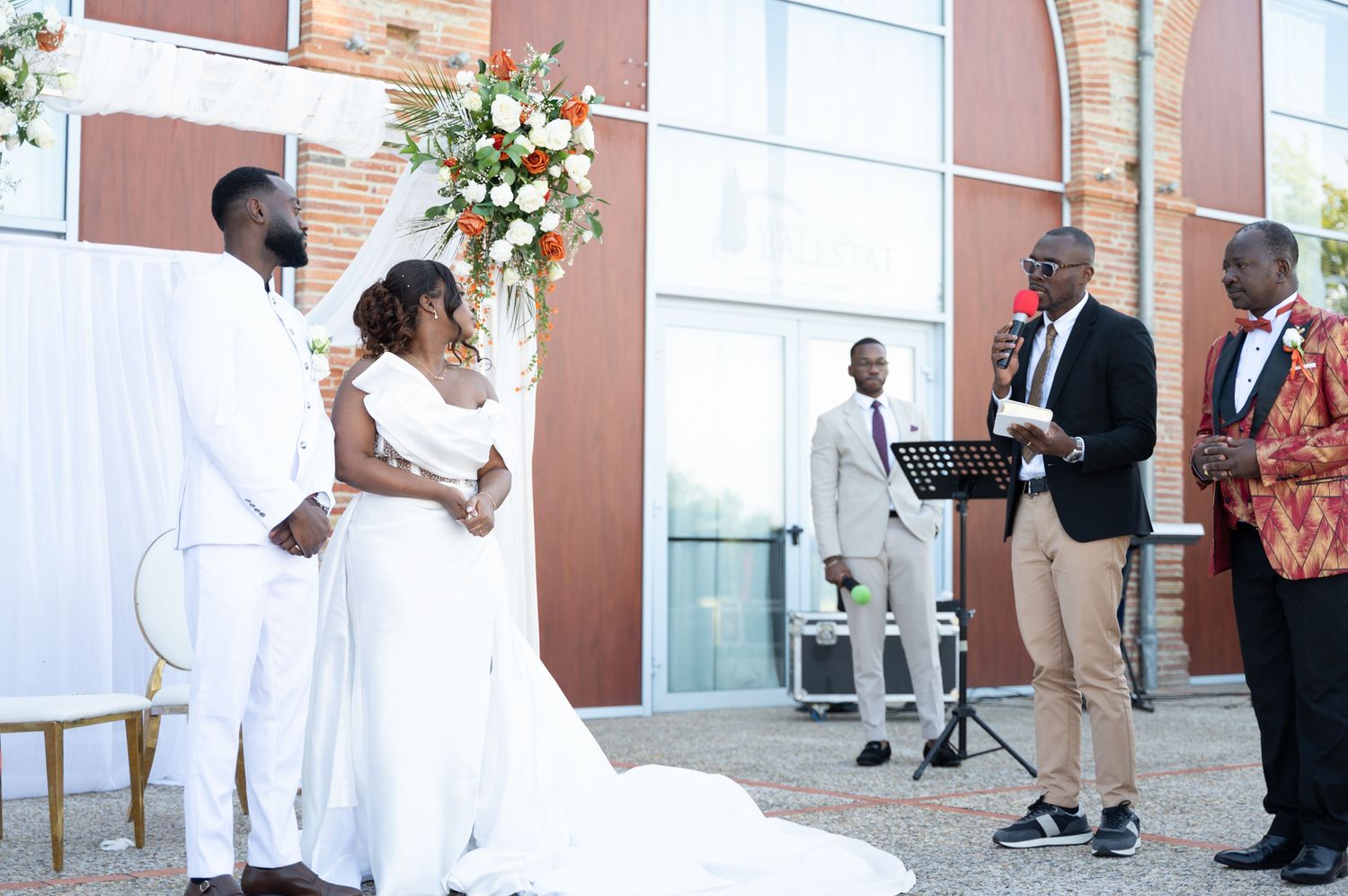 Bride and groom stand at altar as officiant reads during outdoor wedding ceremony.