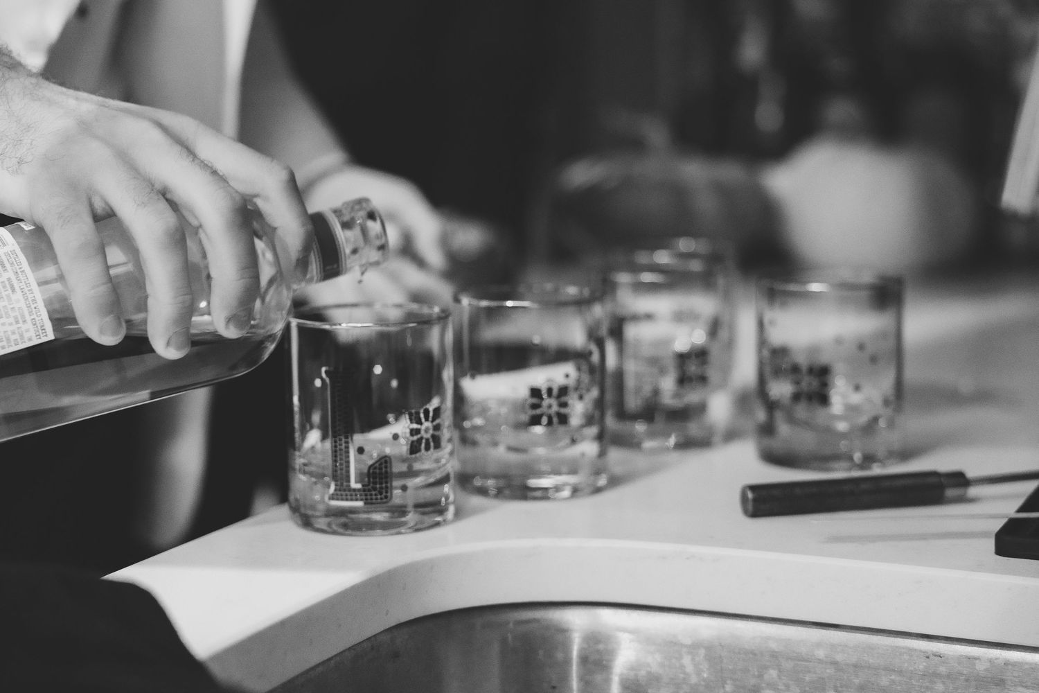 Wedding party members in formal attire toast with drinks at an elegant reception.