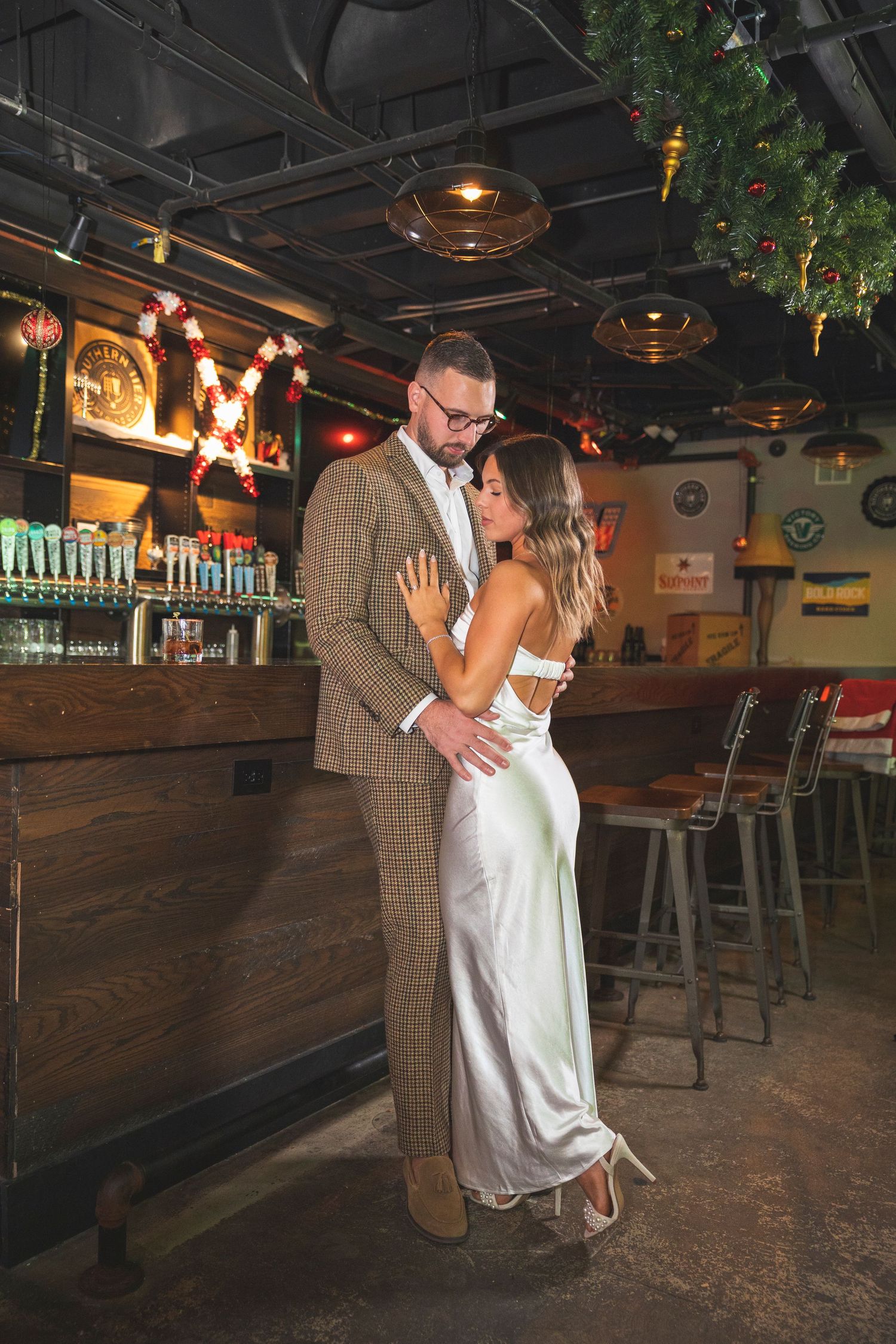 A stylish couple dips and dances in an empty vintage bowling alley with warm ambient lighting.