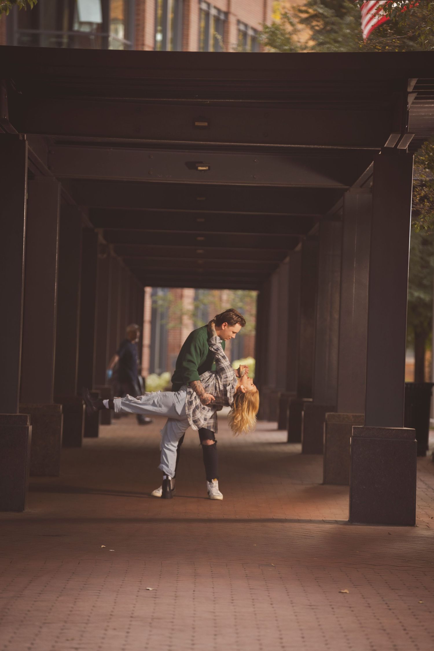Romantic couple dances in a dimly lit covered walkway.