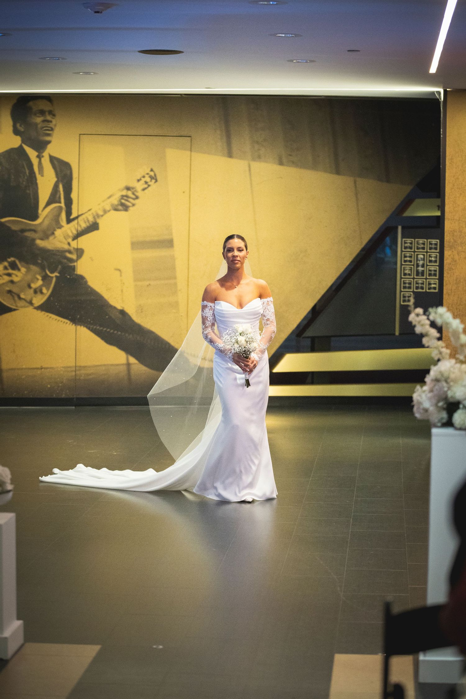 Wedding ceremony space with white floral arrangements and dramatic lighting.