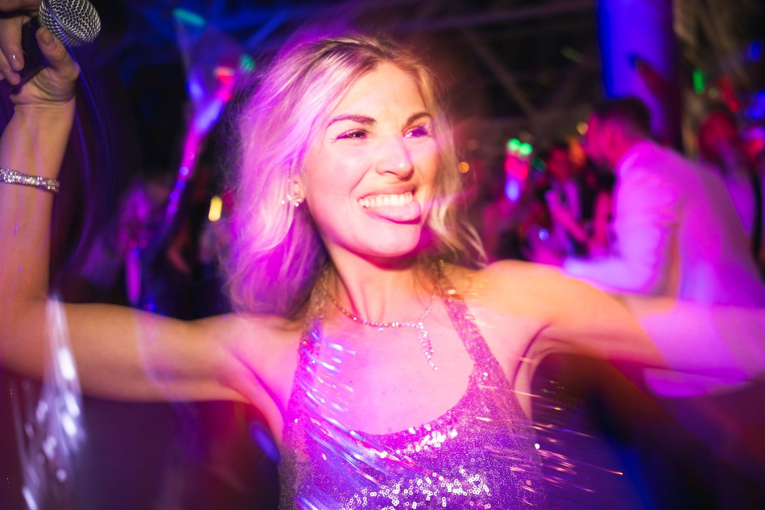 Dance party scene with vibrant pink and purple lighting effects.