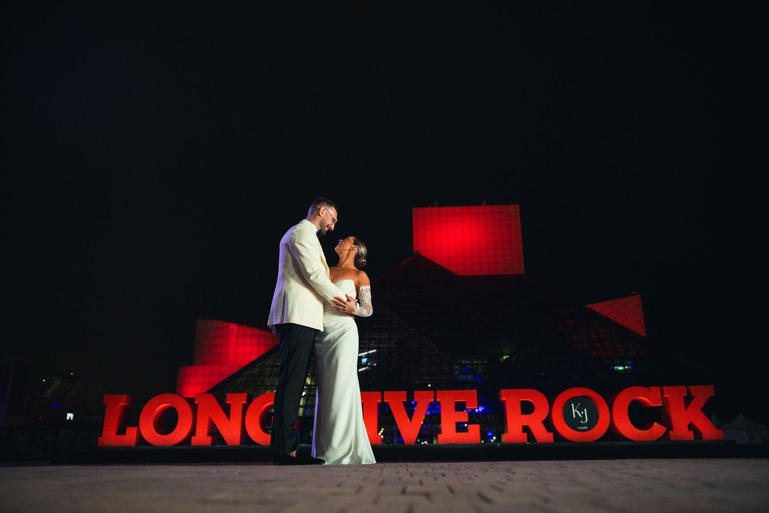 Wedding couple silhouetted against red lighting and text display.