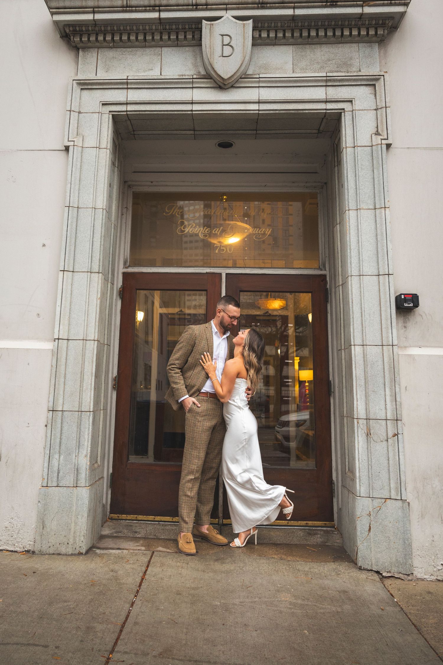 Wedding couple poses playfully in a series of shots near a classic stone building entrance.