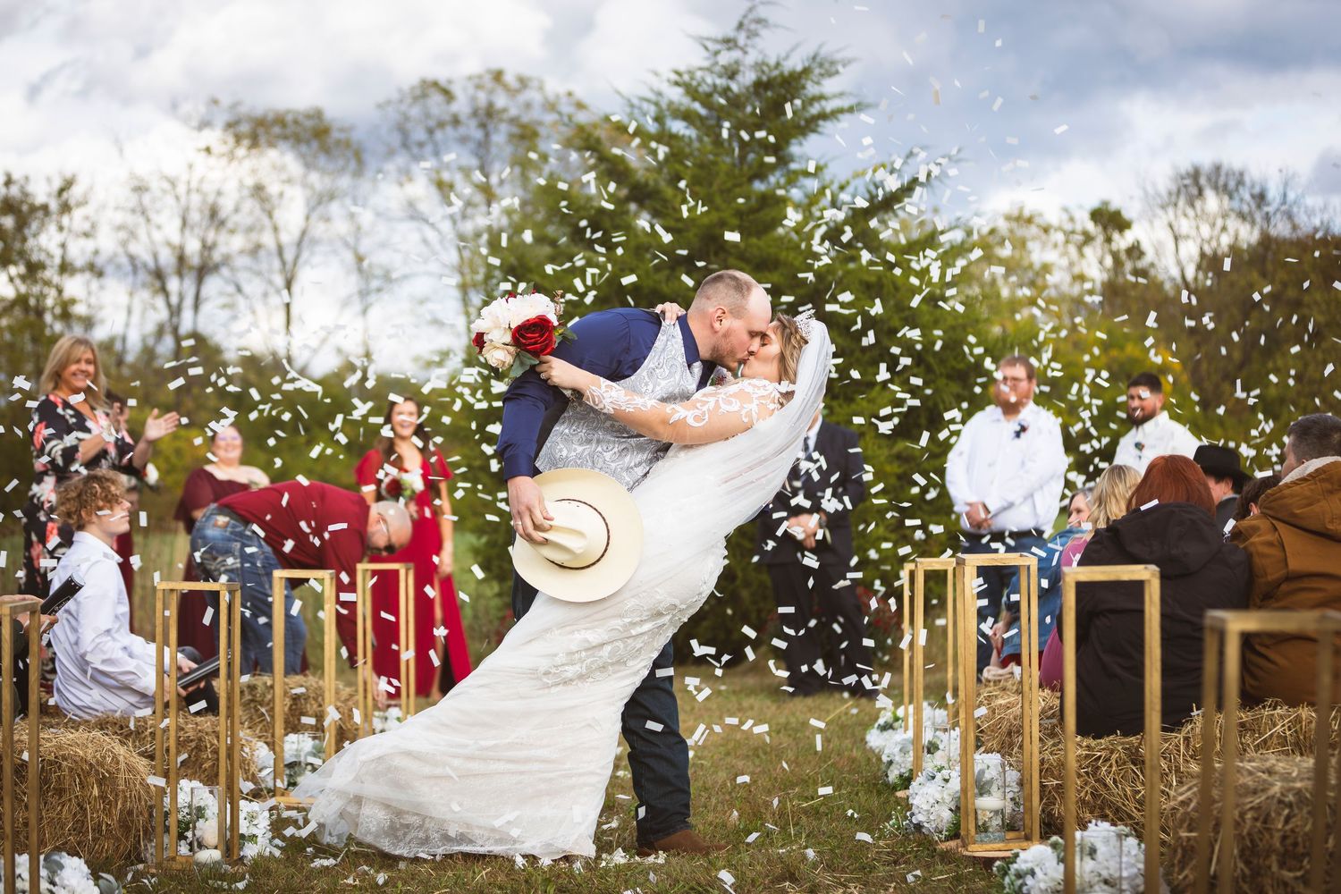 Wedding celebration in a garden setting with confetti flying through the air on a sunny day.