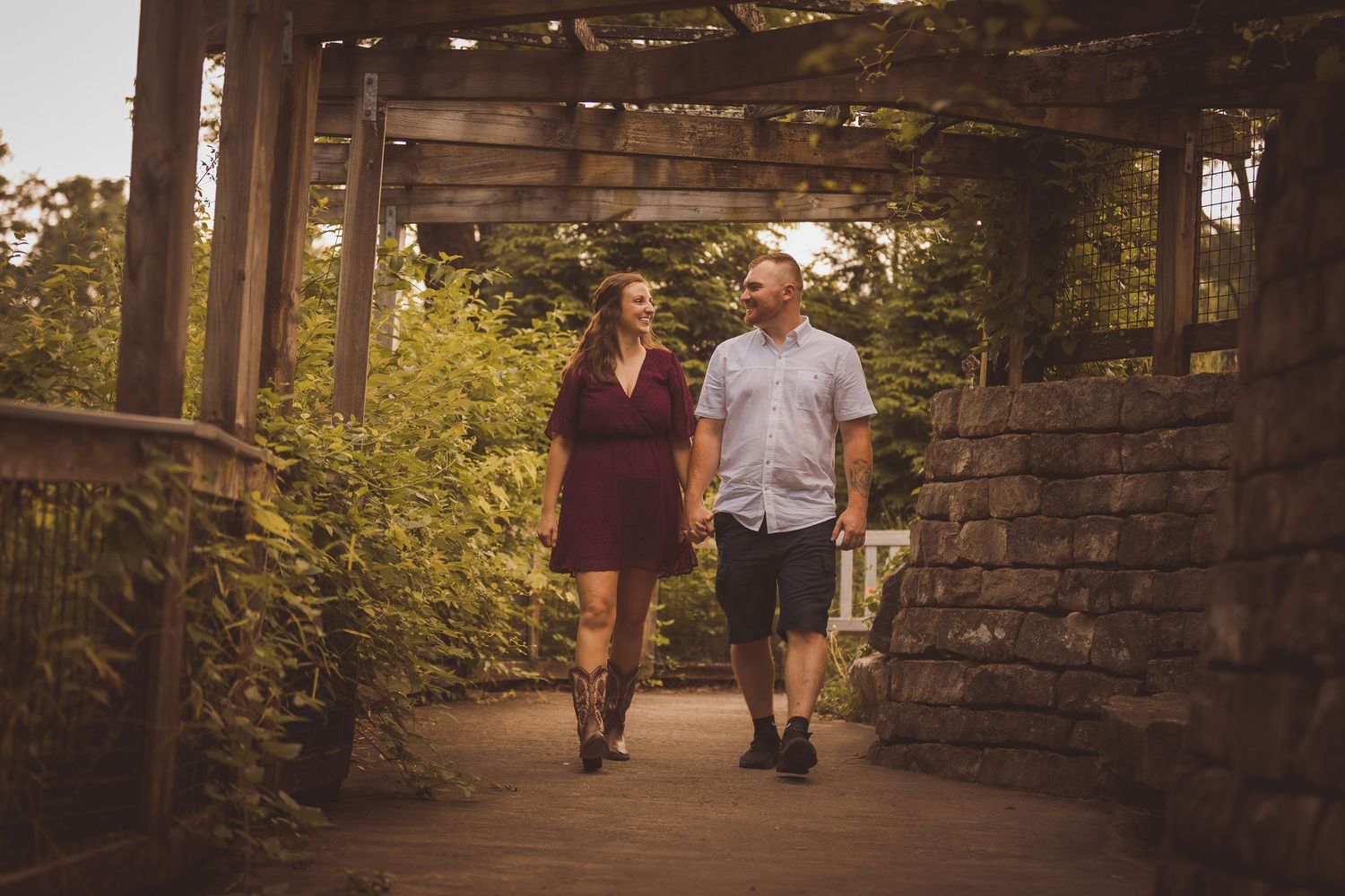 Two people walking along a stone path in a beautiful garden setting.