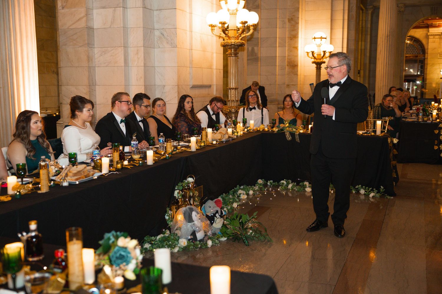 Long banquet tables set for a wedding reception with floral arrangements and candlelight.