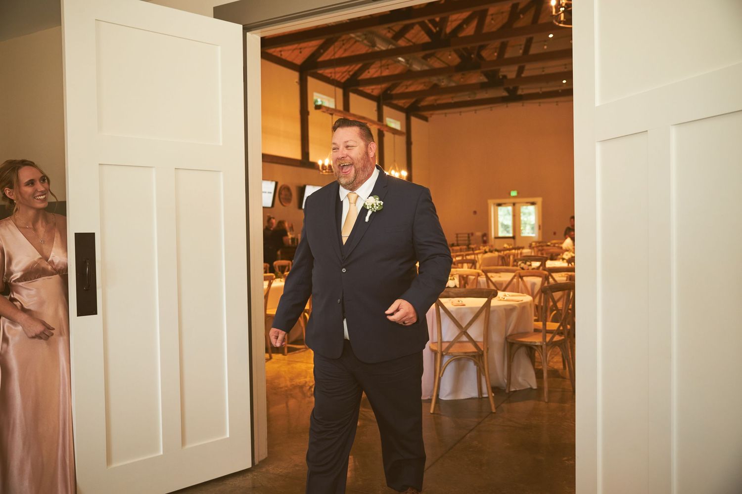 Interior view of a rustic wedding venue with exposed wooden beams.