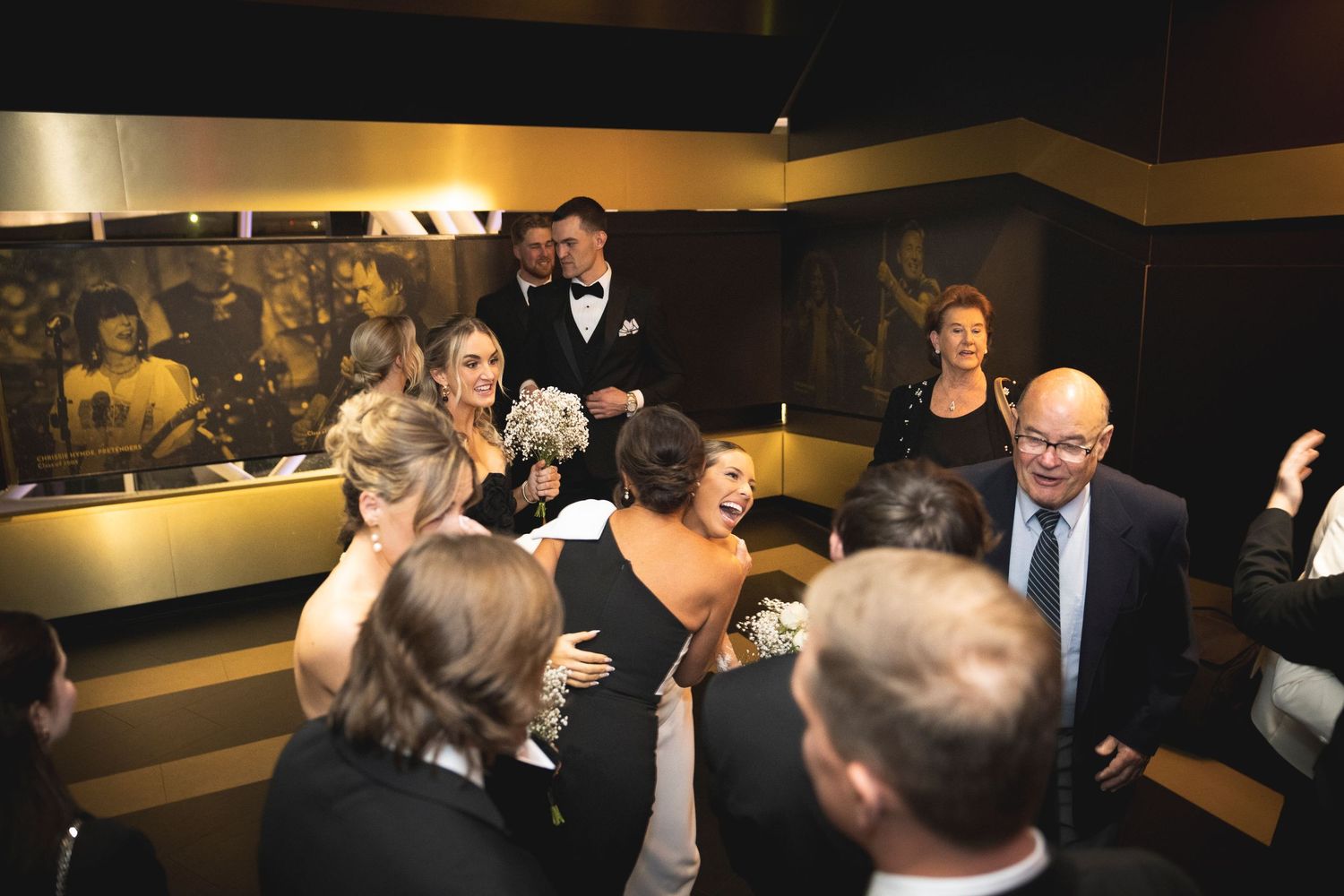 Wedding guests gathered at formal ceremony under dramatic lighting.