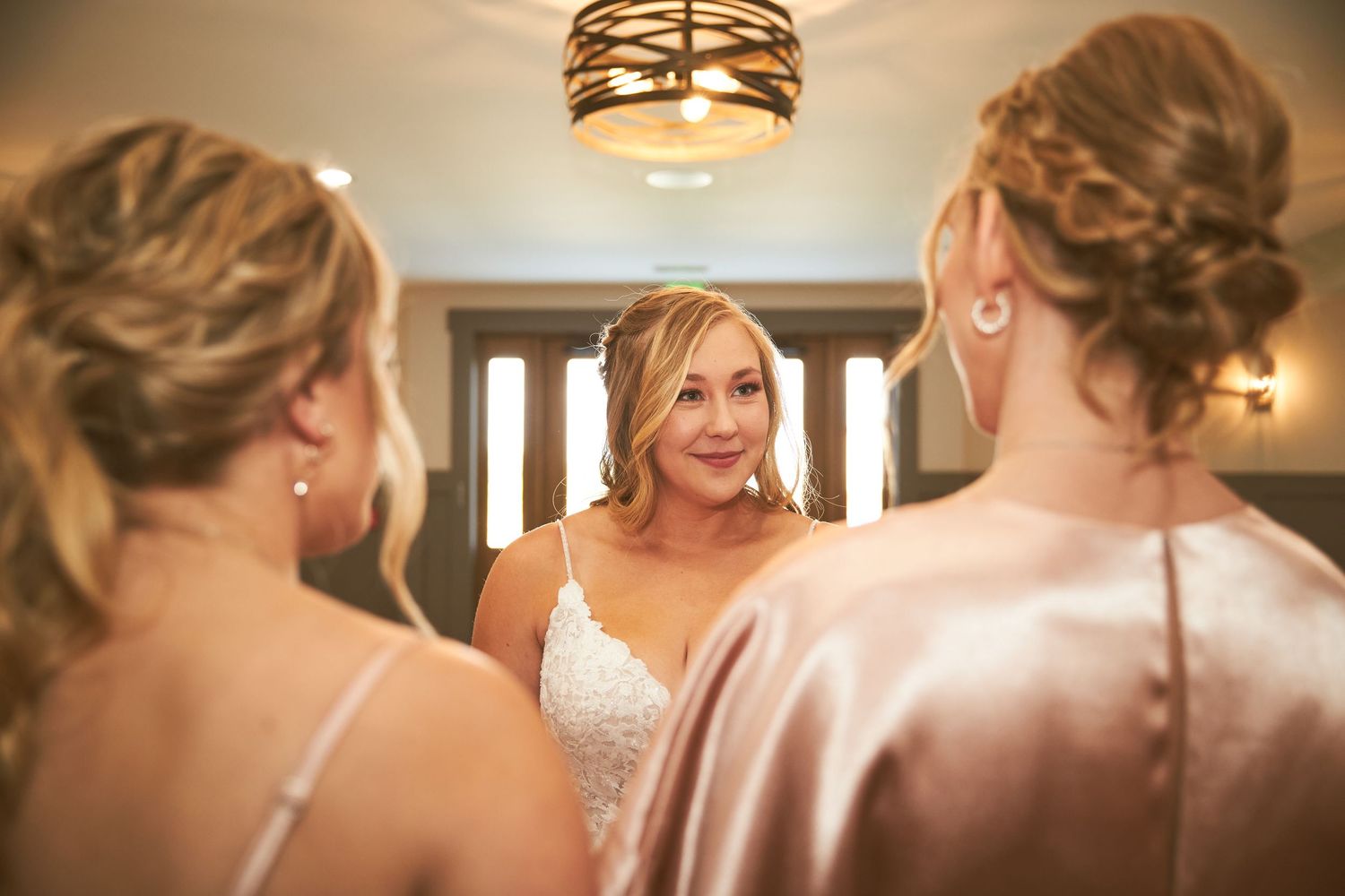 Elegant light fixture illuminates an intimate wedding venue interior.