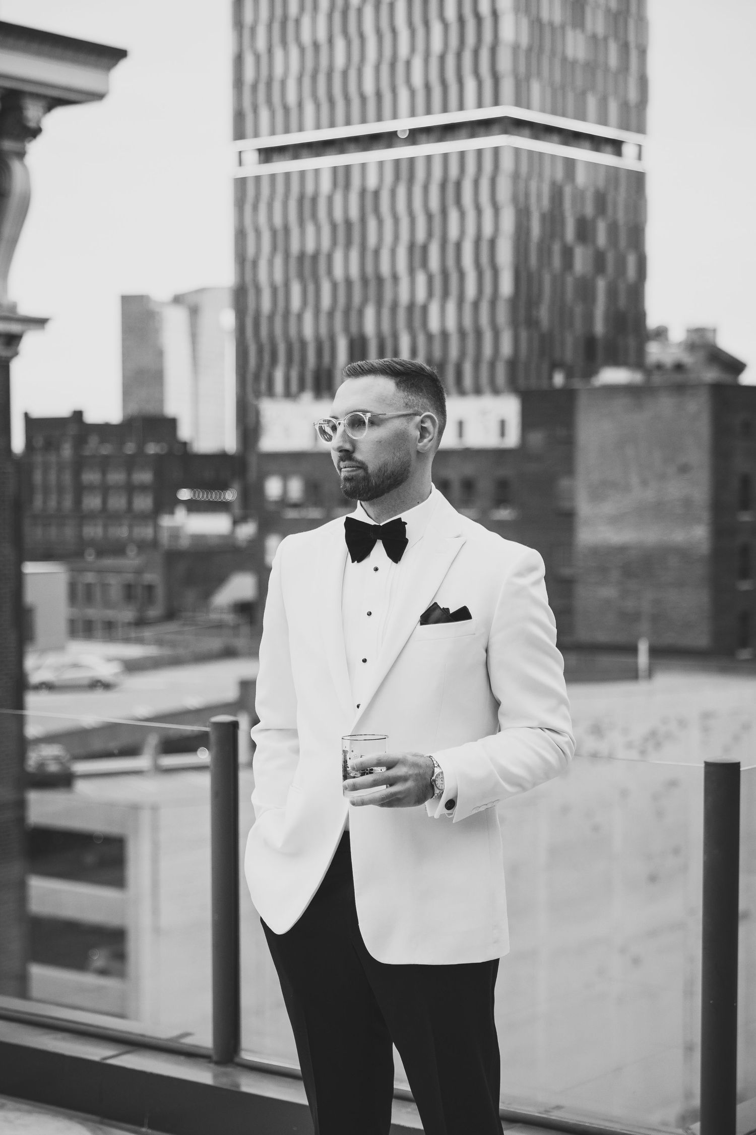 Elegant black and white portraits on a rooftop featuring formal wedding attire.