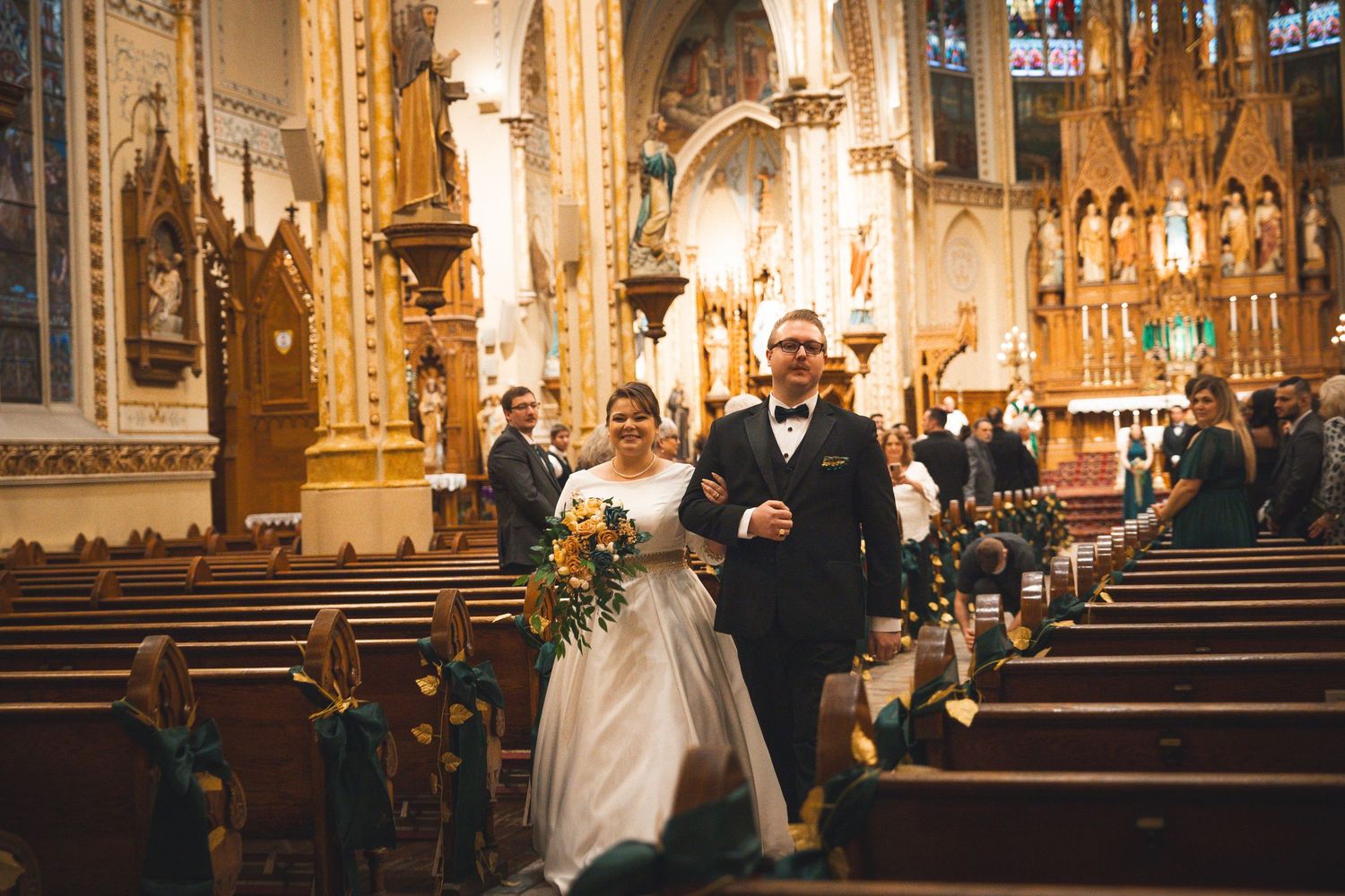 A wedding recessional down the aisle of a magnificent cathedral with vaulted ceilings.