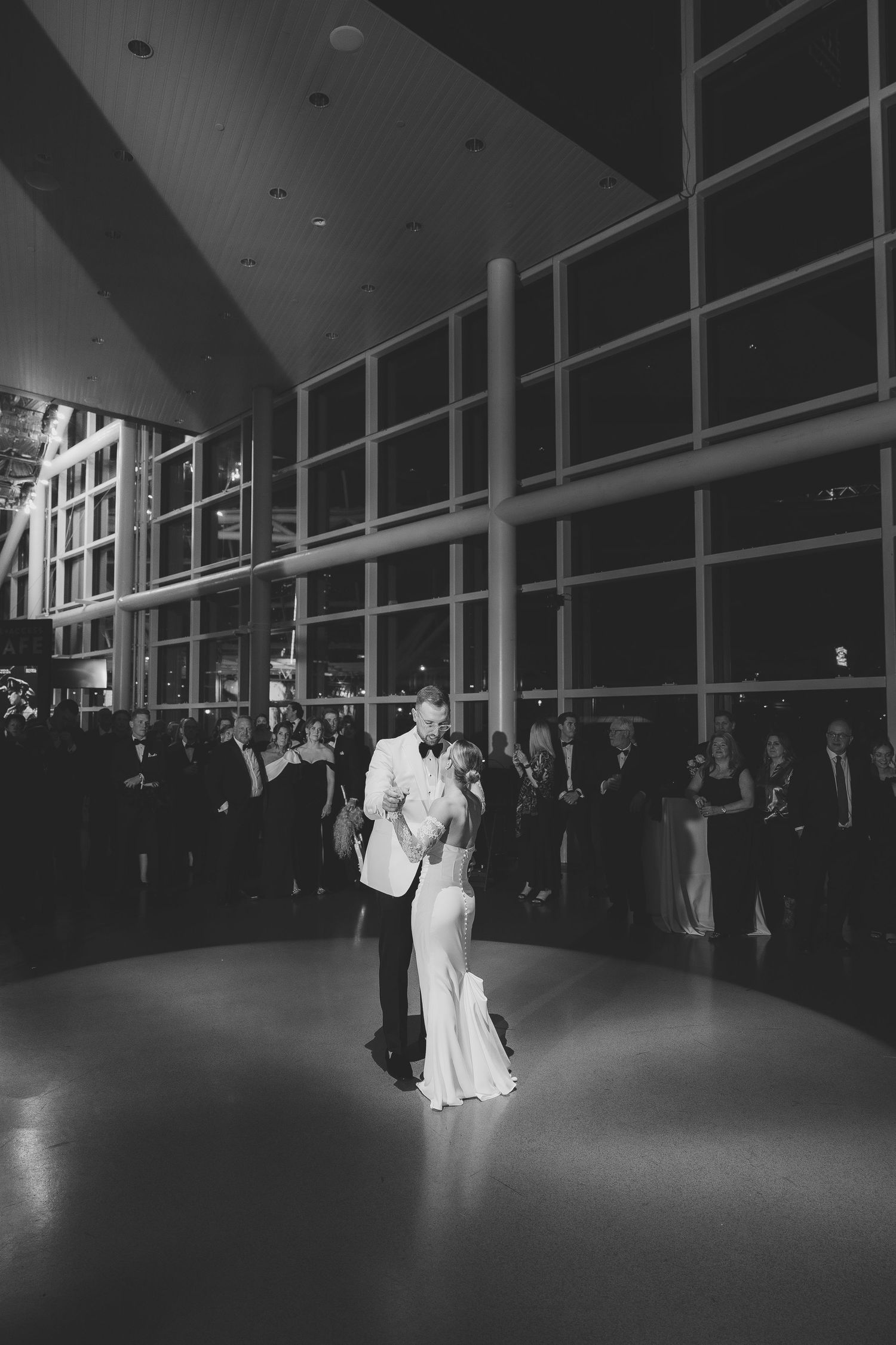 A dramatic black and white wedding first dance sequence shows a couple performing an elegant dip on the dance floor.