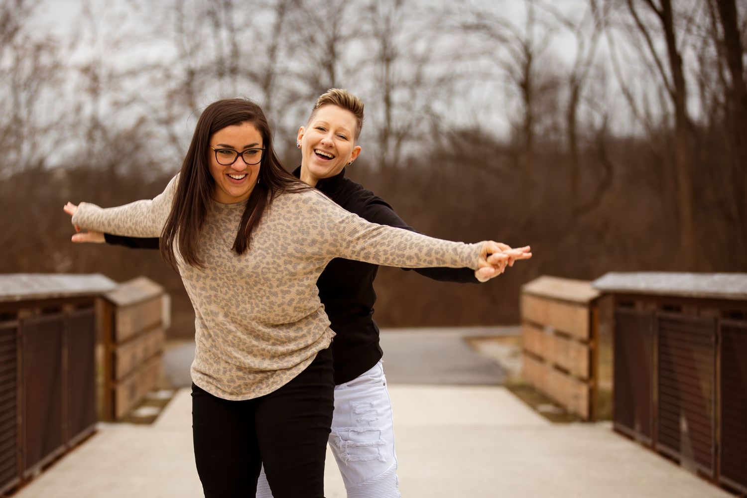 Couple sharing romantic moments on a rustic bridge during autumn.