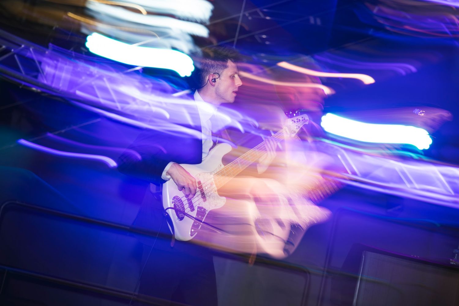 Motion-blurred dancers creating streaks of blue and white light on the dance floor.