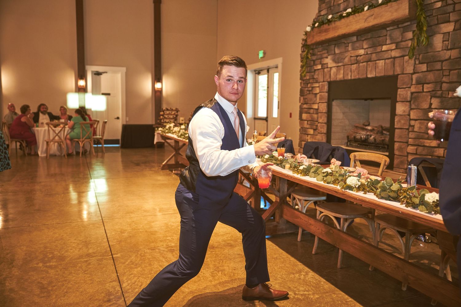Wedding reception venue features rustic wood details and brick walls with elegant lighting.