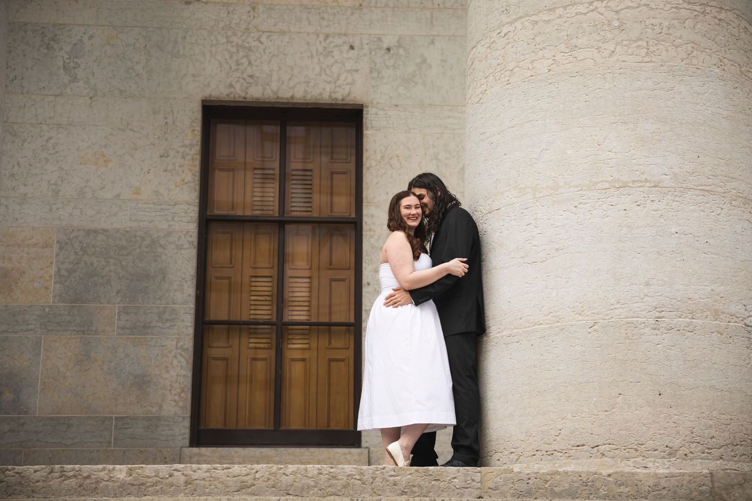 A romantic photoshoot sequence showing different poses against a stone wall with columns.