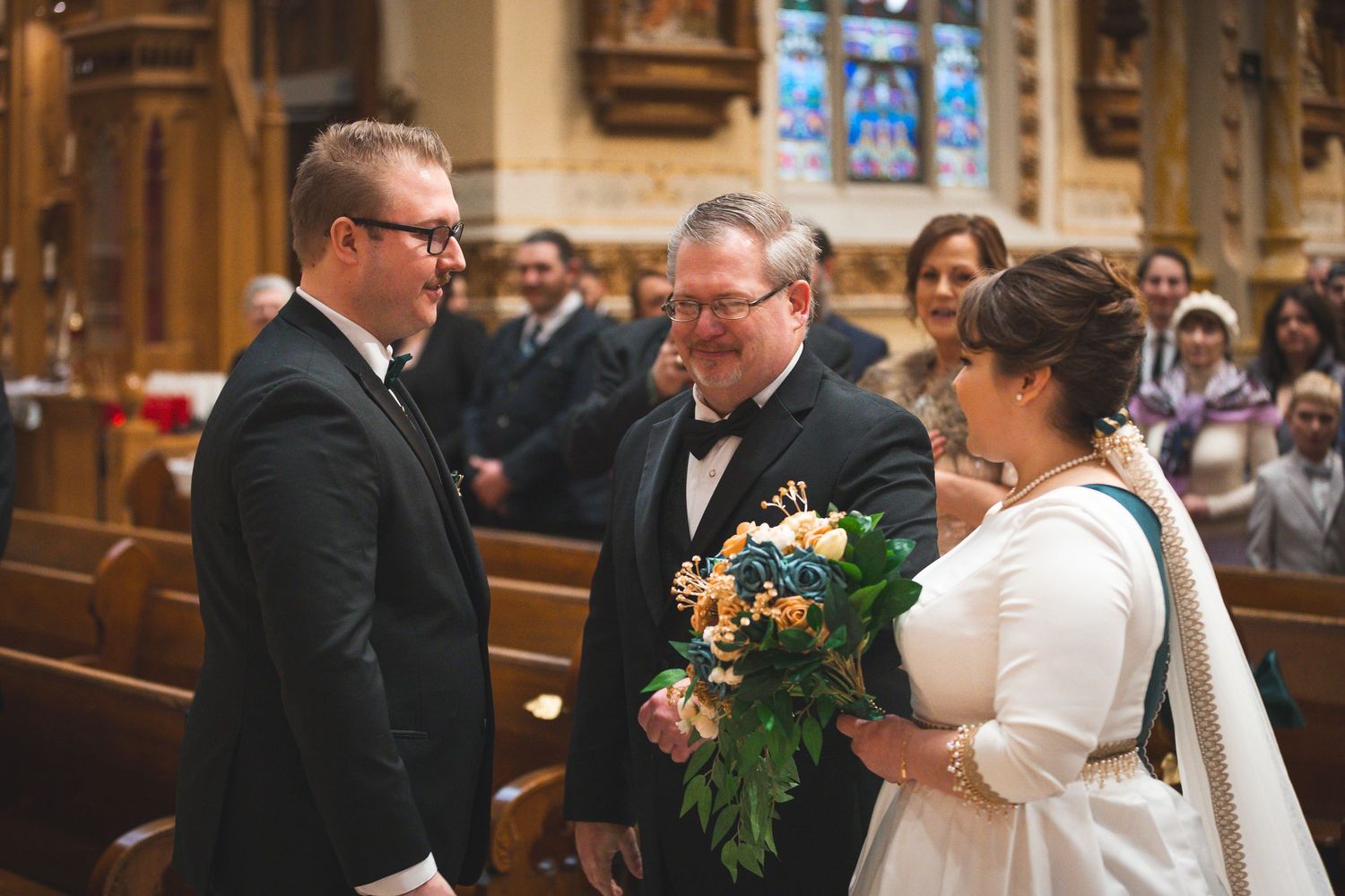 Wedding ceremony in a historic church with stained glass windows and traditional decor.