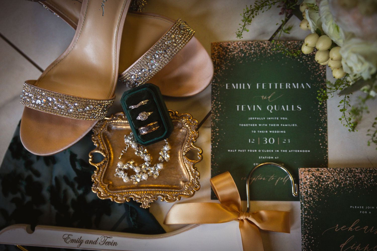 Wedding details including invitation, shoes, and jewelry arranged on textured backgrounds.