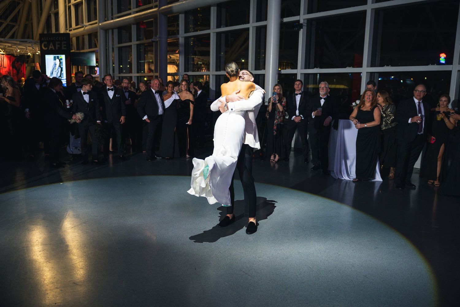 Wedding celebration in progress at contemporary venue with dramatic lighting.