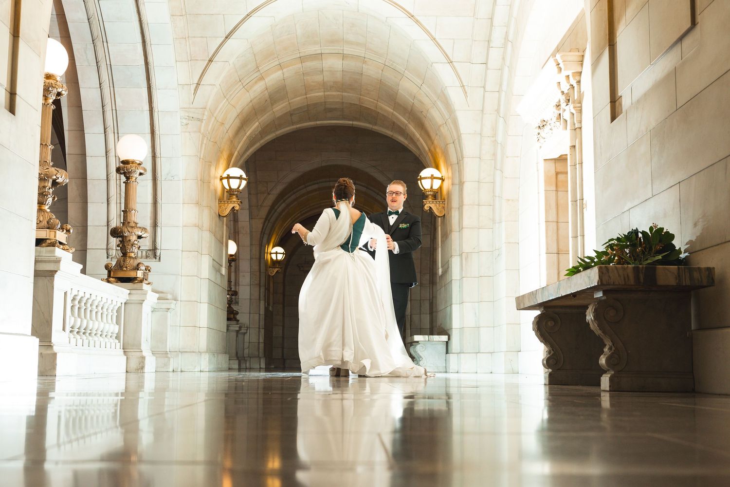Long hallway with white stone archways and columns in classic architectural style.