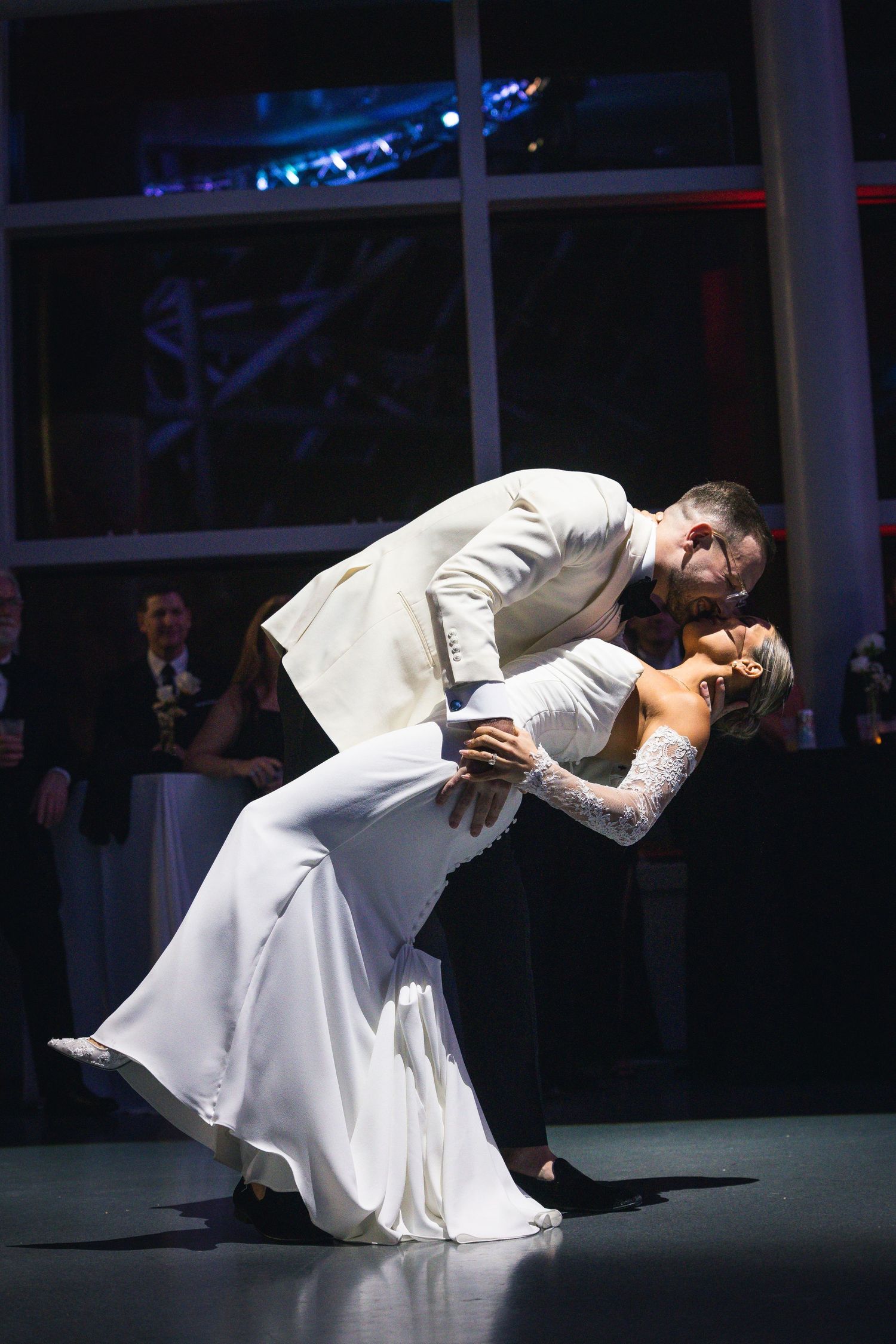 A beautiful dance dip captured during a wedding reception with dramatic lighting and shadows.