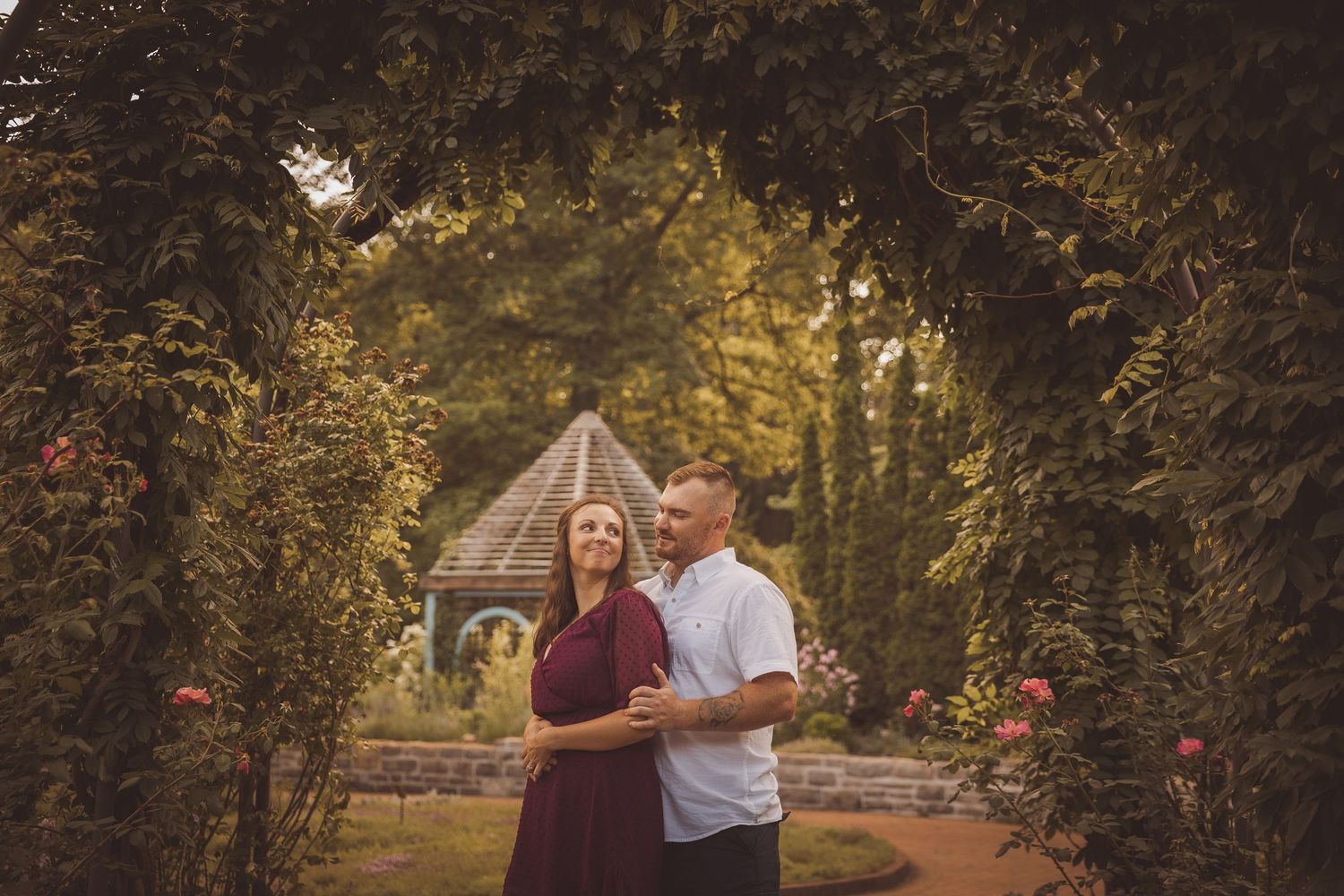 A romantic photoshoot in a garden setting with autumn foliage and natural lighting.