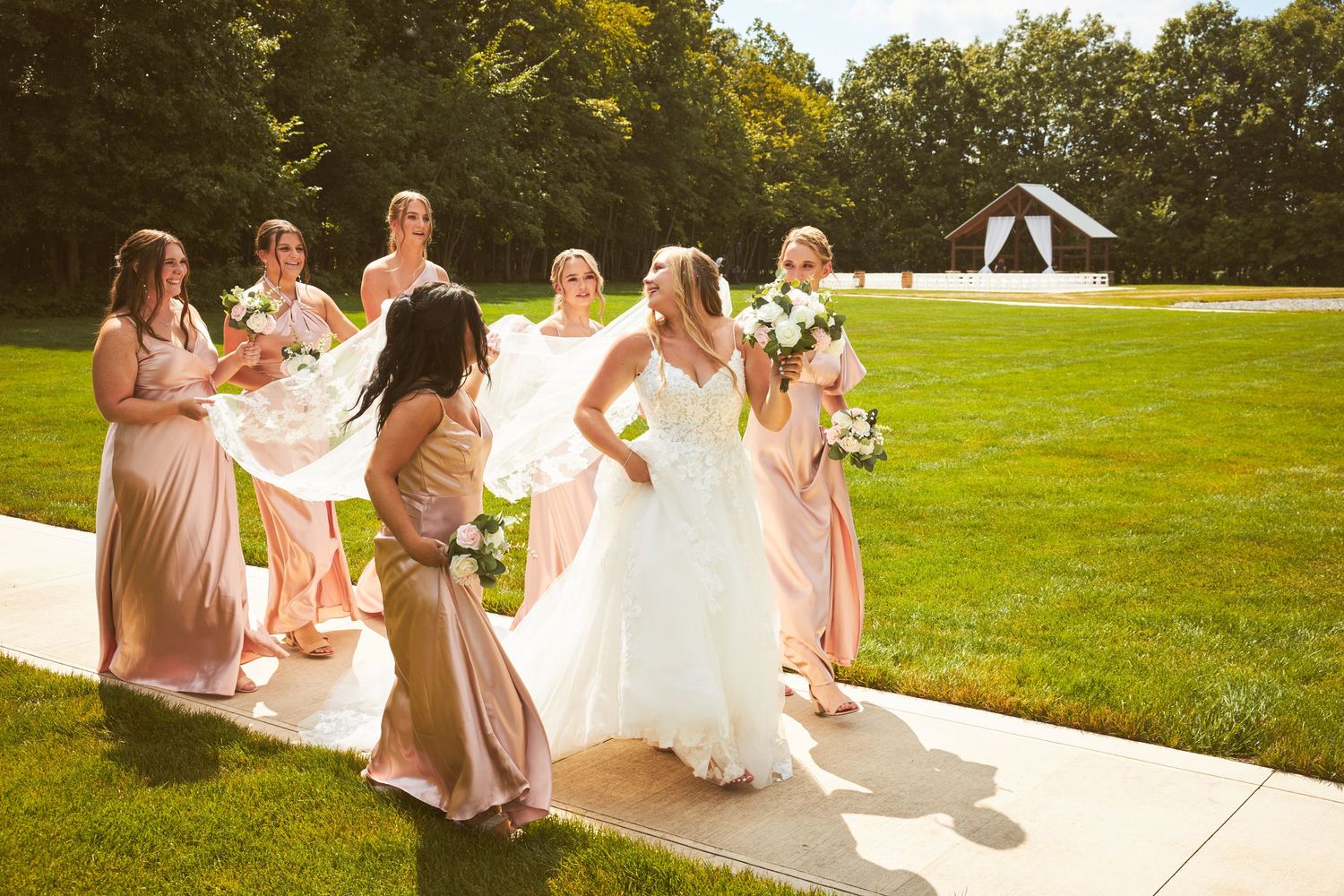 Wedding party relaxing on grass in outdoor garden setting.