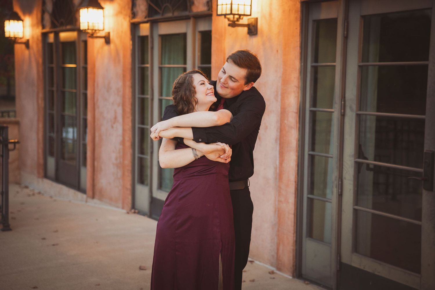 A couple dancing together in an elegant interior setting with warm lighting and classic architecture.