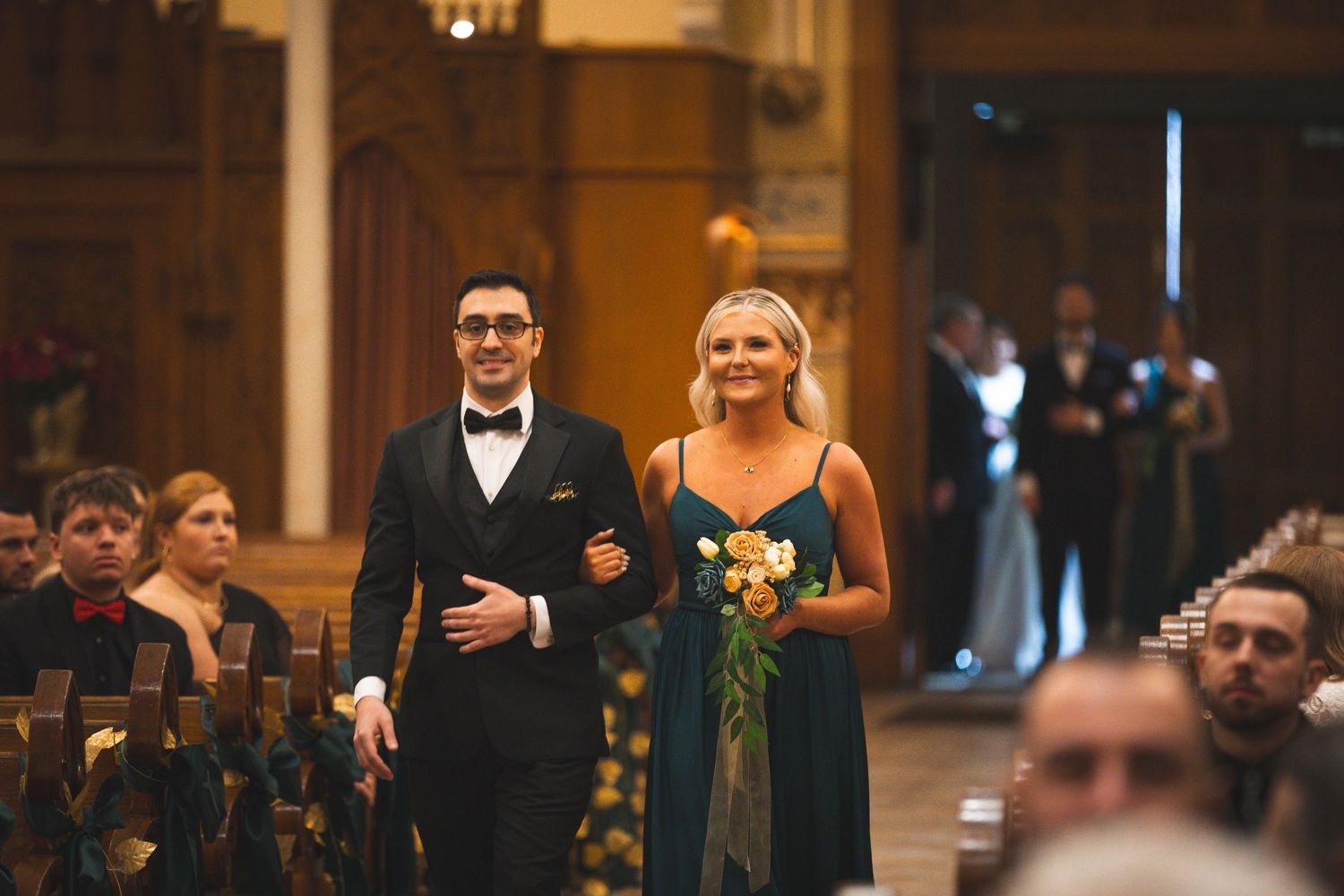 Wedding ceremony procession in elegant indoor venue with warm lighting.