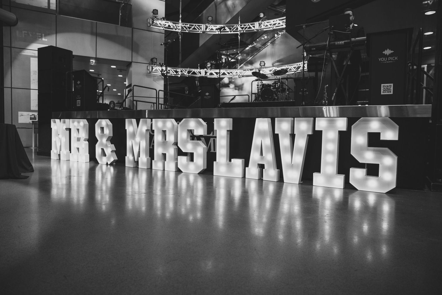 Illuminated wedding venue sign displayed with glowing letters against dark background.