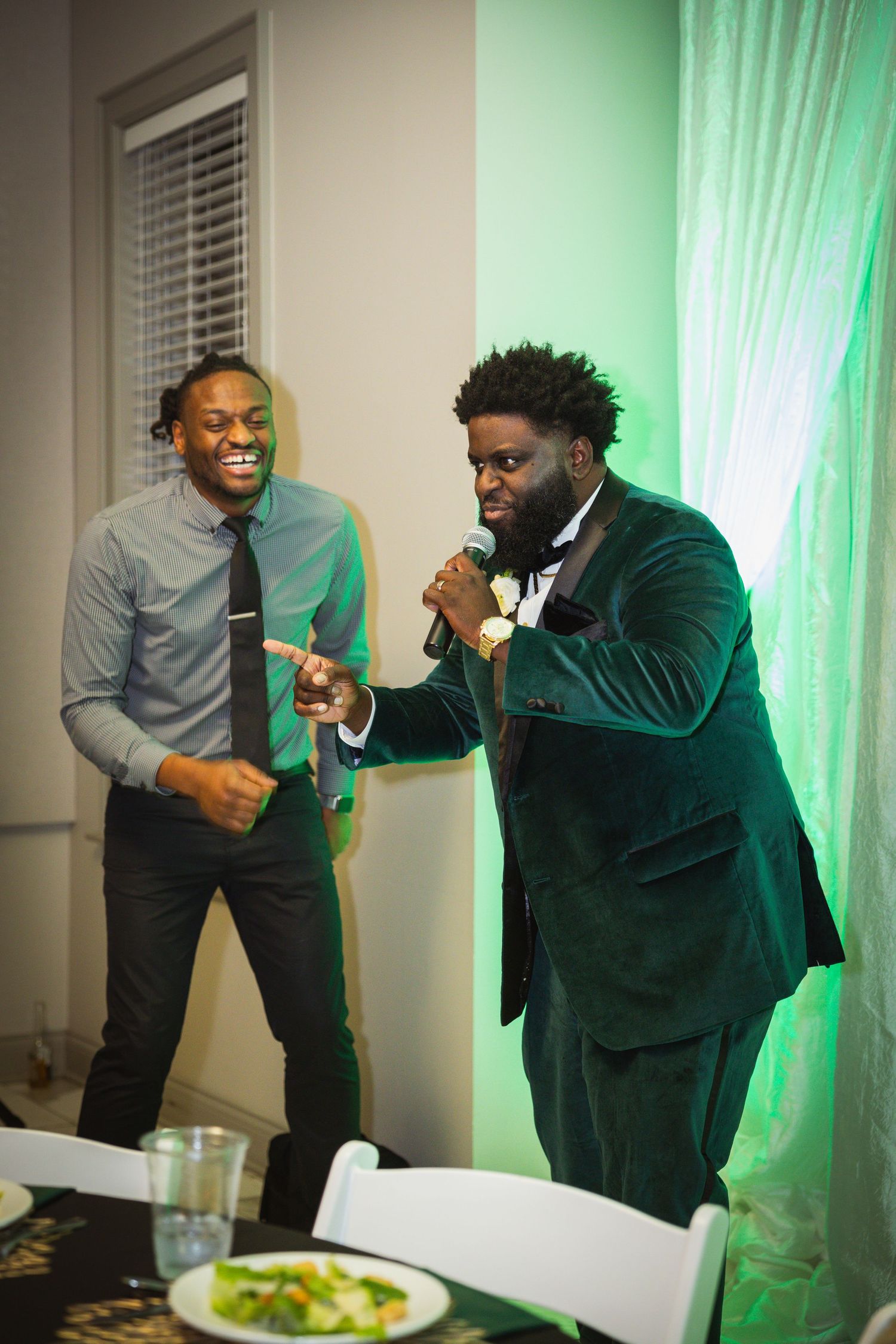 Sequence of candid moments showing two guests sharing laughter in front of green-lit curtains.