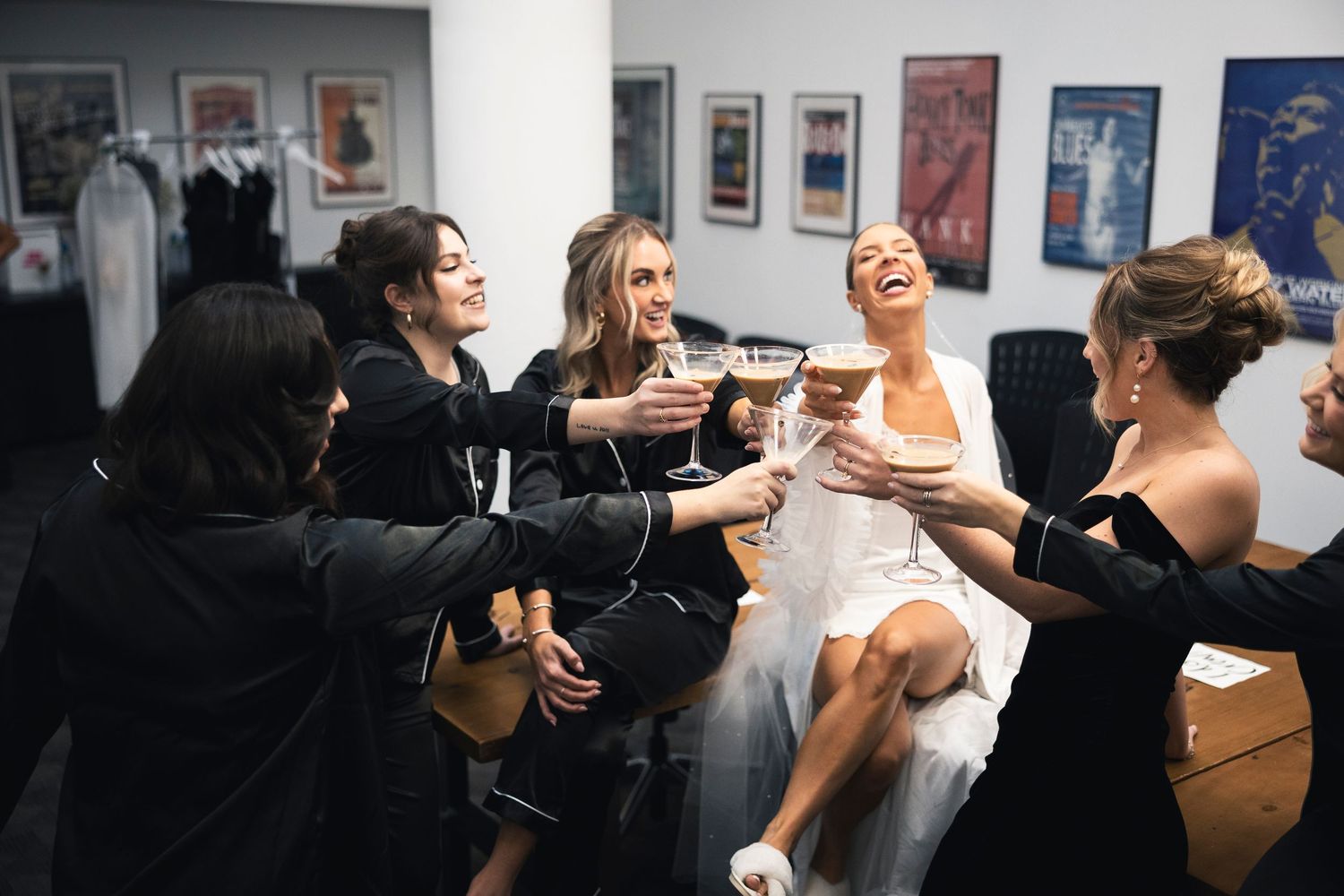 Joyful celebratory moment in a gallery space with guests mingling and holding champagne glasses.