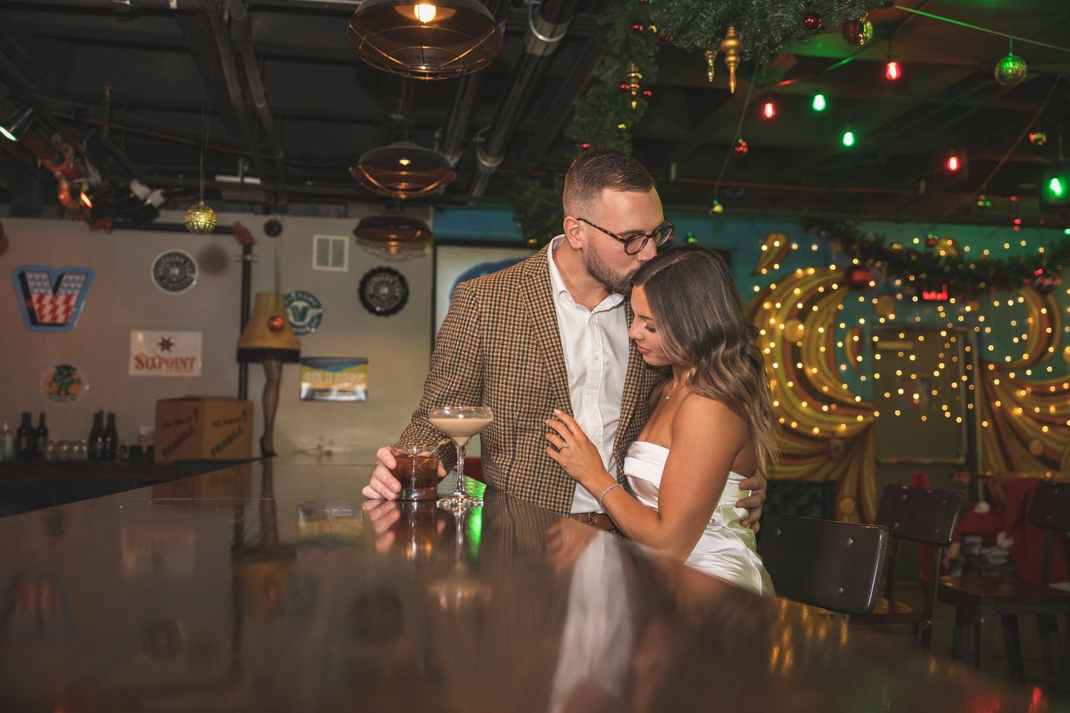 Bar interior with green and red holiday lights creating a festive atmosphere for a couple.