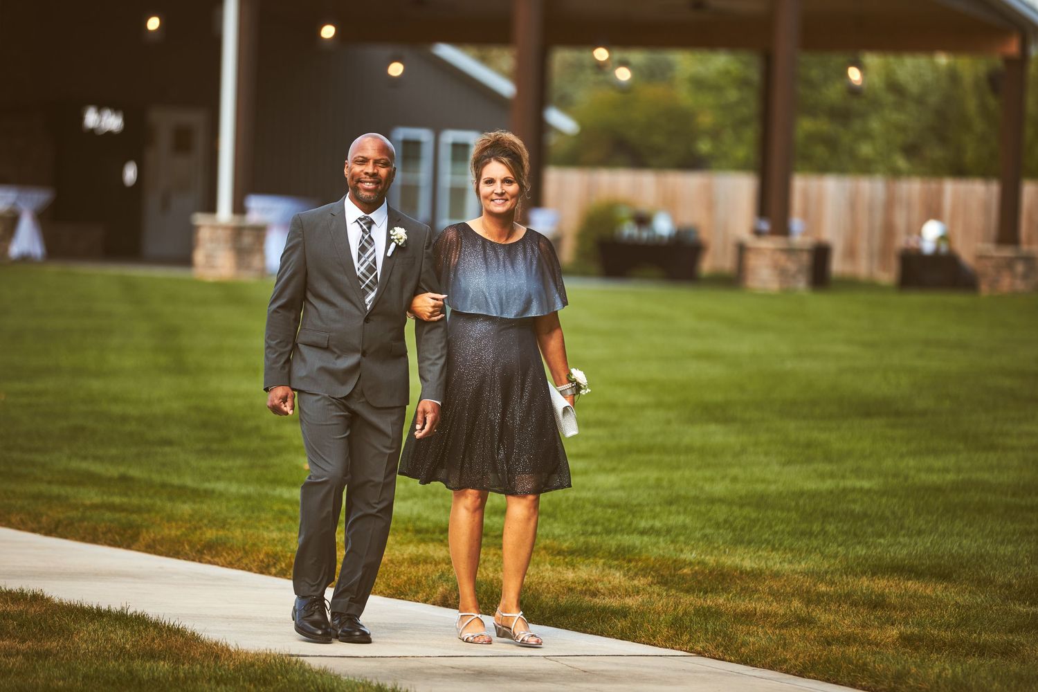 Wedding guests walk along a path during an outdoor reception.