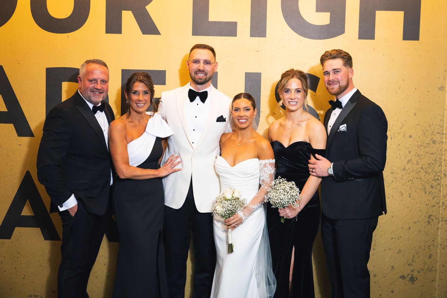 Wedding celebration with formal guests under yellow lighting.