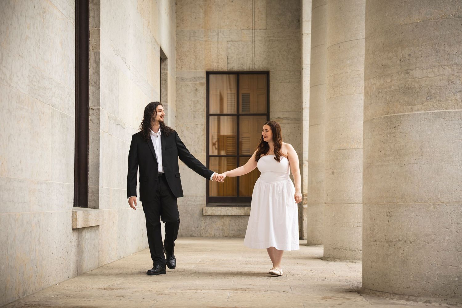 Couple's photoshoot sequence showing movement and interaction in an elegant columned space.