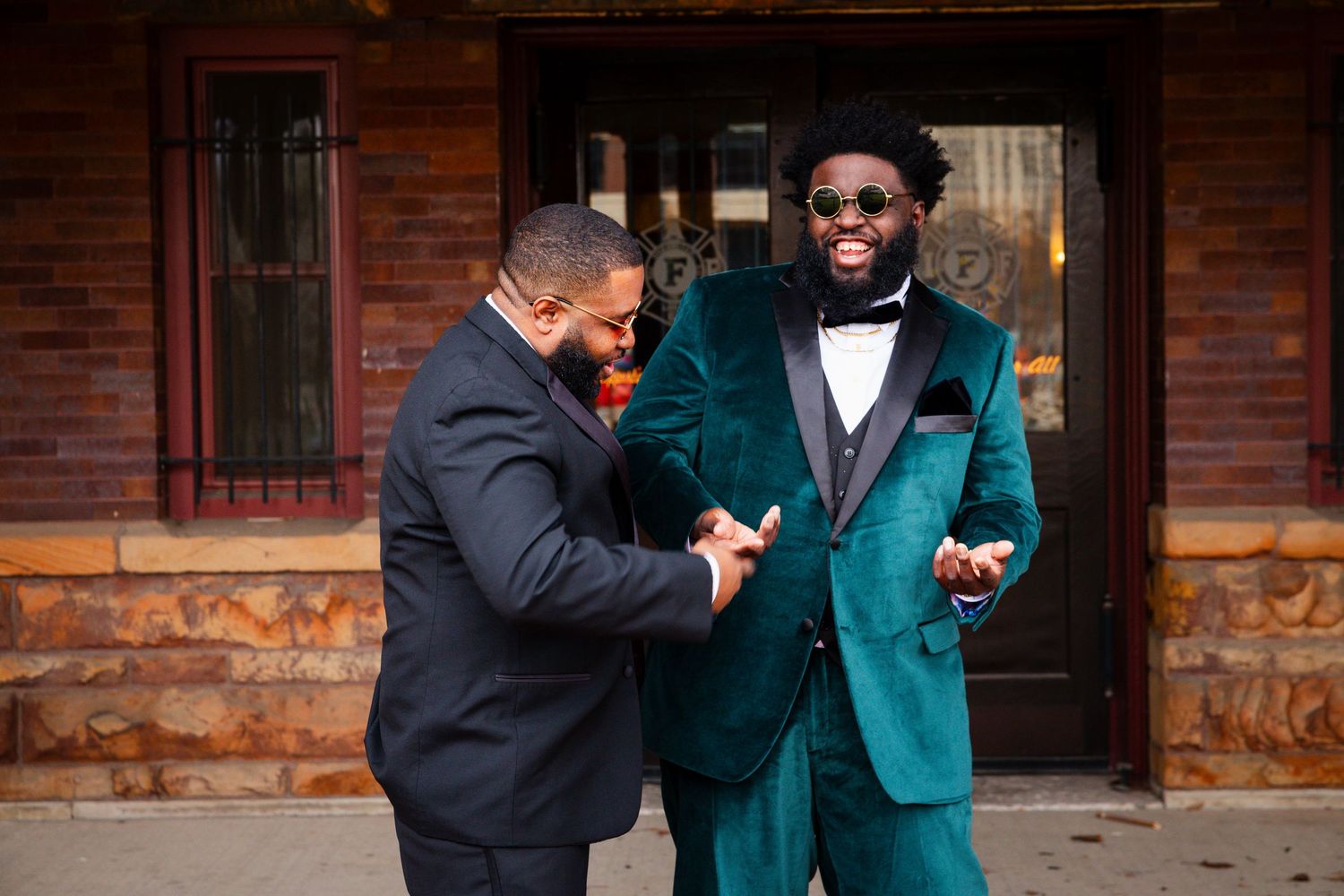 Wedding party members share candid moments in emerald and black formal wear.